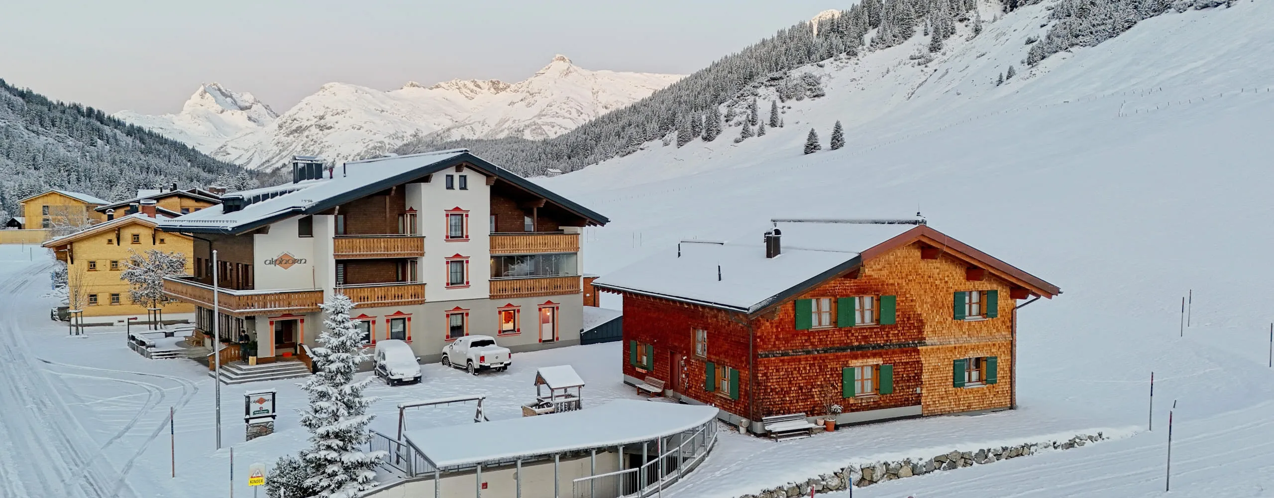 Winteransicht des Gasthof Alphorn mit verschneiten Bergen