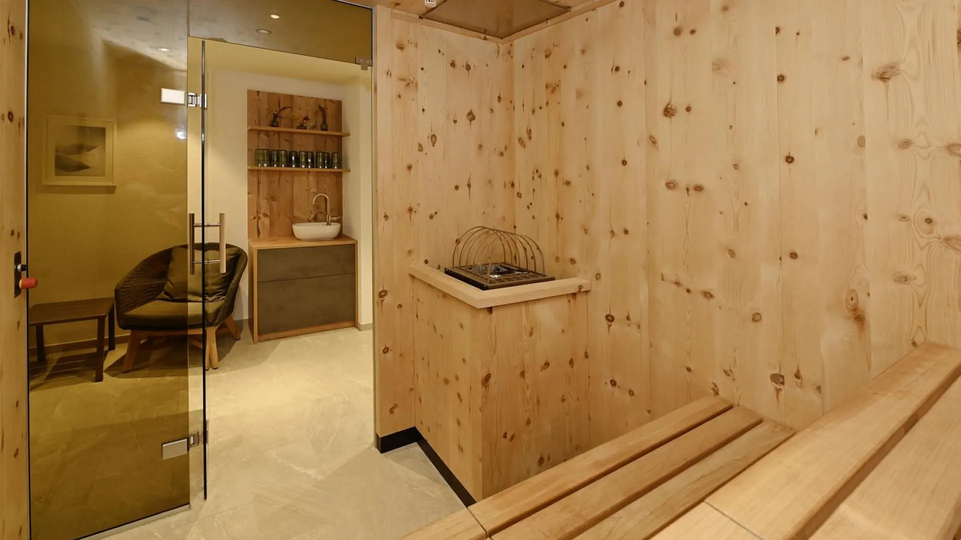 Holzverkleidete Sauna mit Sitzbank und Glastür