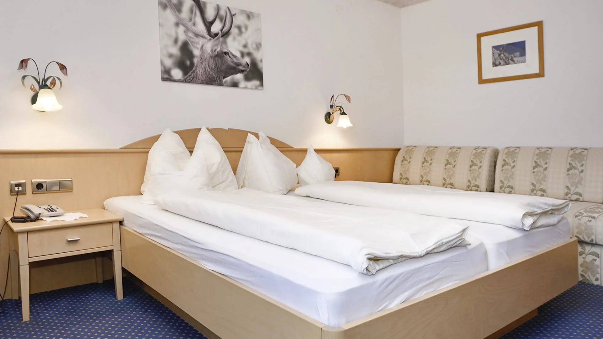 Ein Schlafzimmer mit zwei Betten, Nachttisch und Couch.