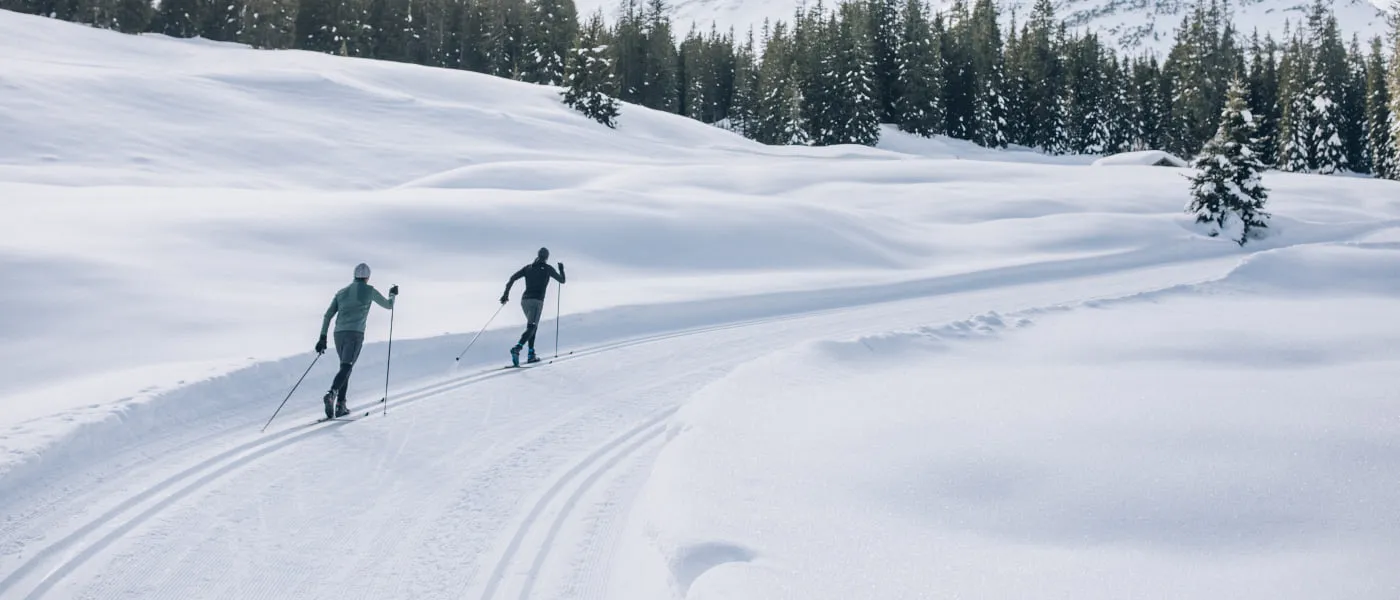 Zwei Langläufer auf einer verschneiten Strecke in Lech Zürs.